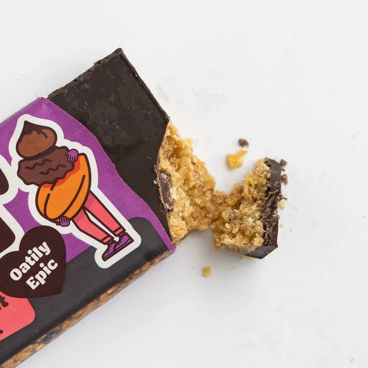 Oatily Epic chocolate bar with a bite taken out of it on a white background