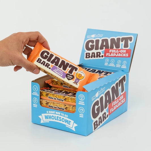 Hand reaching for a Giant Bar from an open box on a white background