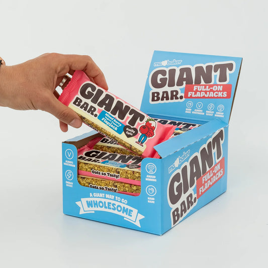 Hand opening a box of Giant Bar Full-On Flapjacks with a visible bar inside.