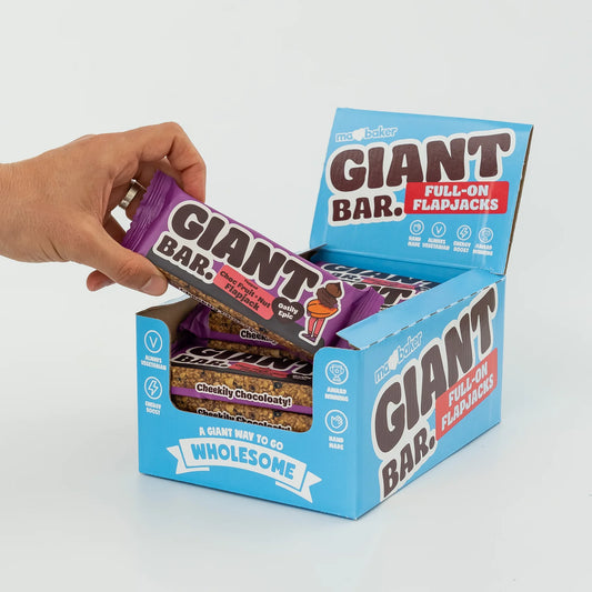 Hand reaching into a box of Giant Bar flapjacks on a white background
