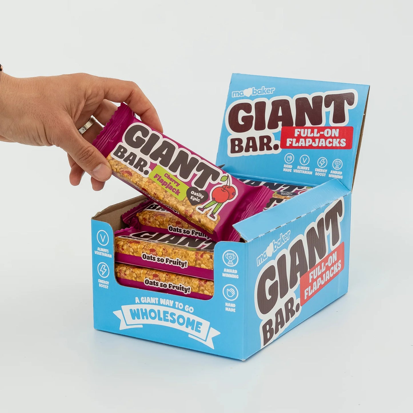 Box of Giant Bar flapjacks with a hand taking one out on a white background