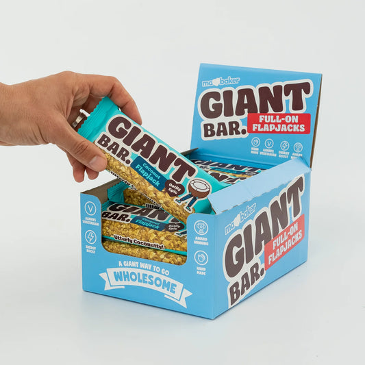 Hand opening a box of Giant Bar Full-On Flapjacks with a white background