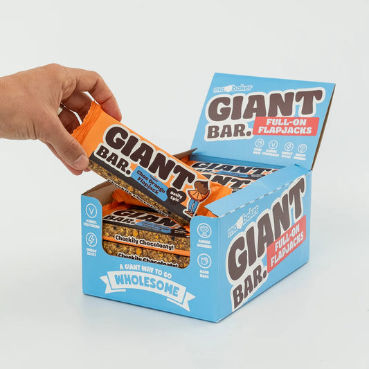 Hand holding a box of Giant Bar Full-On FlapJacks against a white background