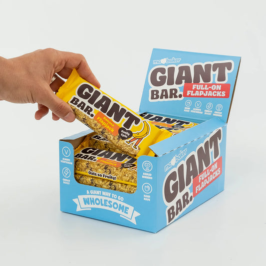 Hand holding a Giant Bar Full-On Flapjacks package with another package in the background.