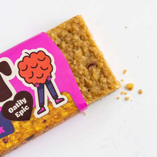 Bar of oatmeal cookie with pink packaging featuring a cartoon character on a white background