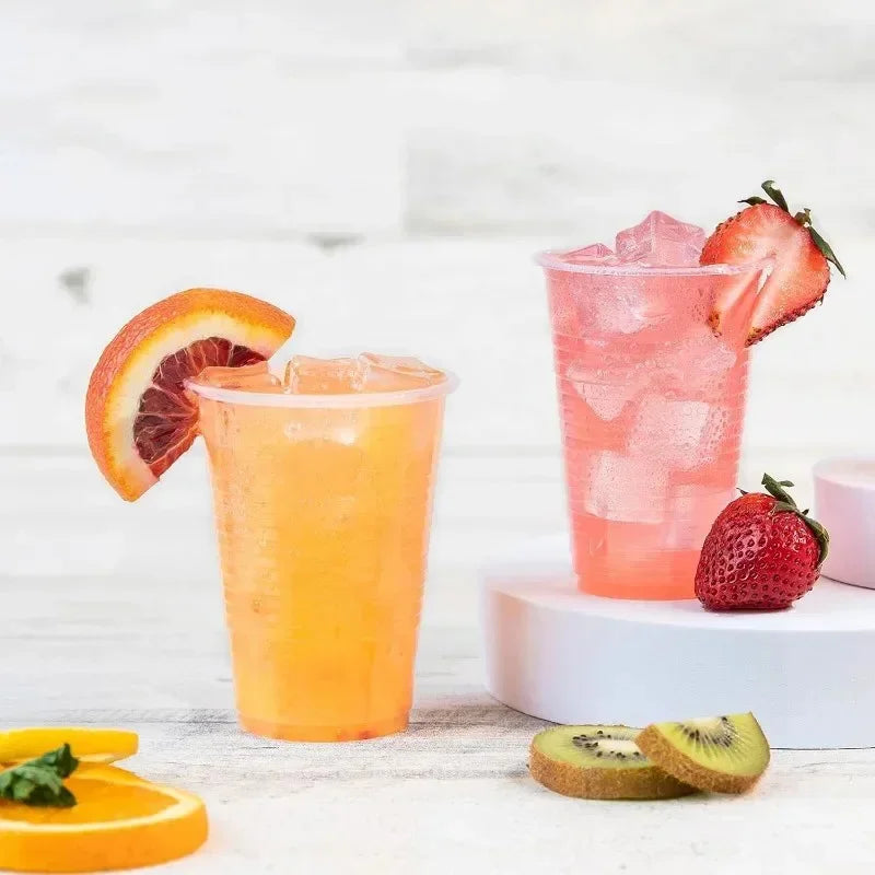 Two glasses of fruit-themed drinks with slices of orange, strawberry, and kiwi on a light background.