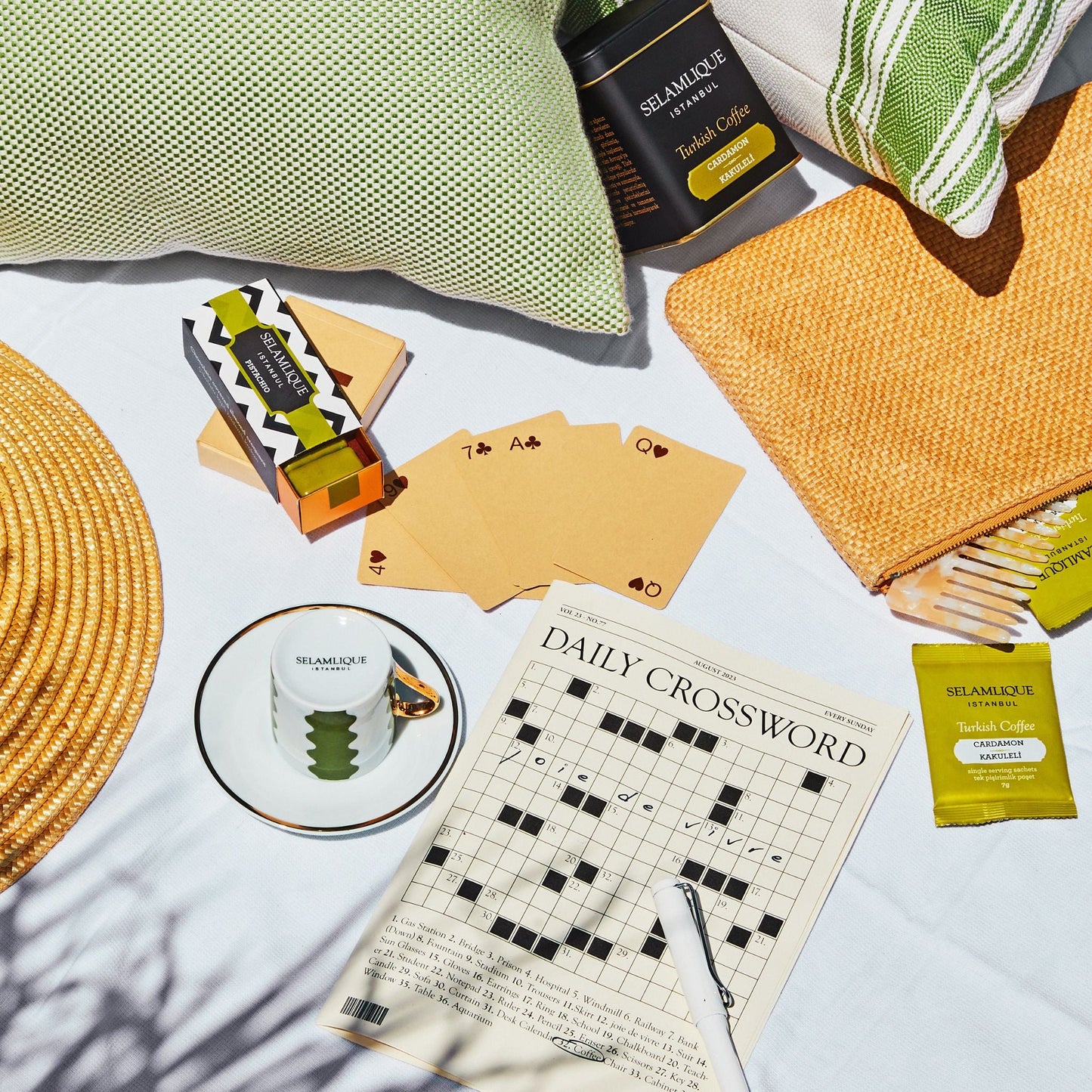 Tabletop items including a crossword puzzle, coffee, and snacks on a light surface.