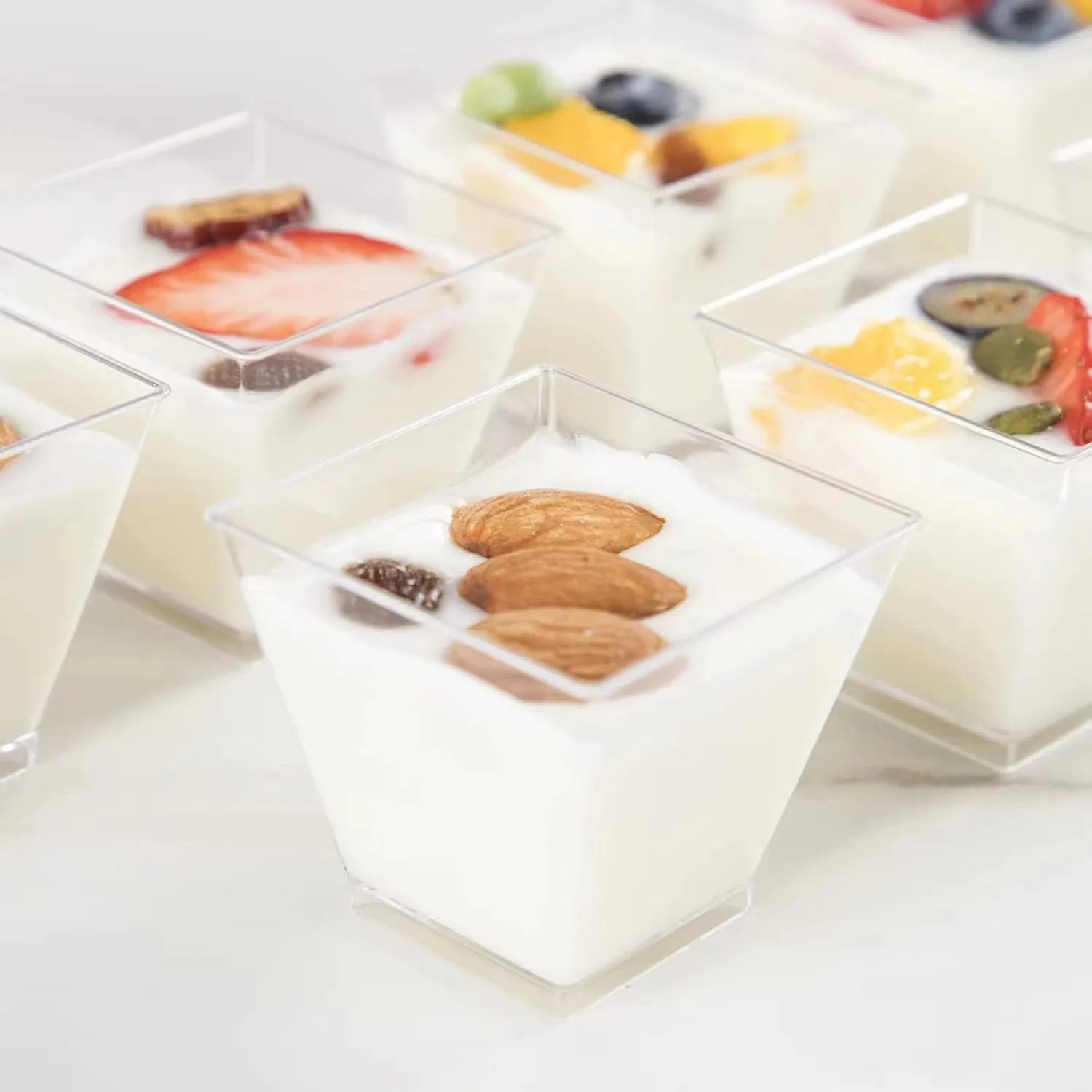 Small glass dishes with various toppings on a white surface