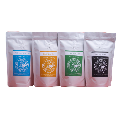 Four white coffee bags with colorful labels on a red background